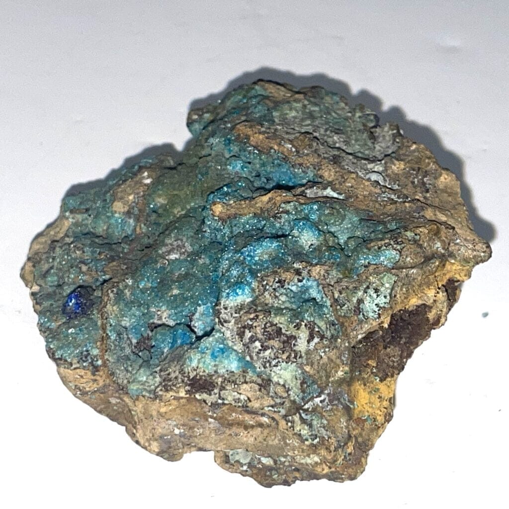 Aqua Blue Smithsonite Specimen features blue-green hues with a Malachite spray on top and an Azurite crystal, accented by brown tones, displayed on a plain white background.