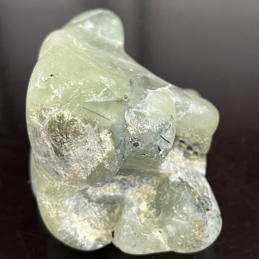 The Prehinite Natural Shaped Tumble Polished 68.4 grams features pale green hues, rough surfaces, and white and gray patches.