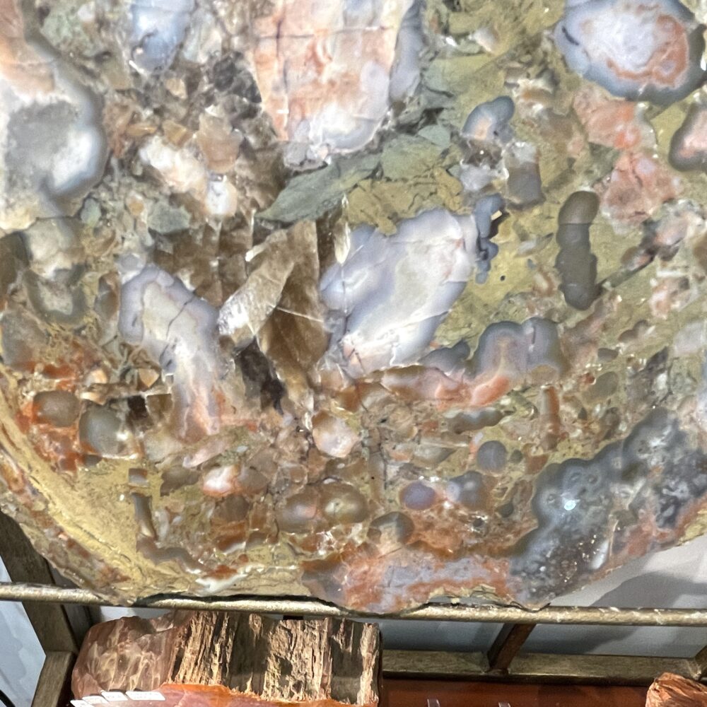 Close-up of the Huge Giant Kentucky Agate Geode Nodule Polished (17 lbs/7700 g) showcasing tan, gray, blue, and orange patterns with polished surfaces and rough edges.