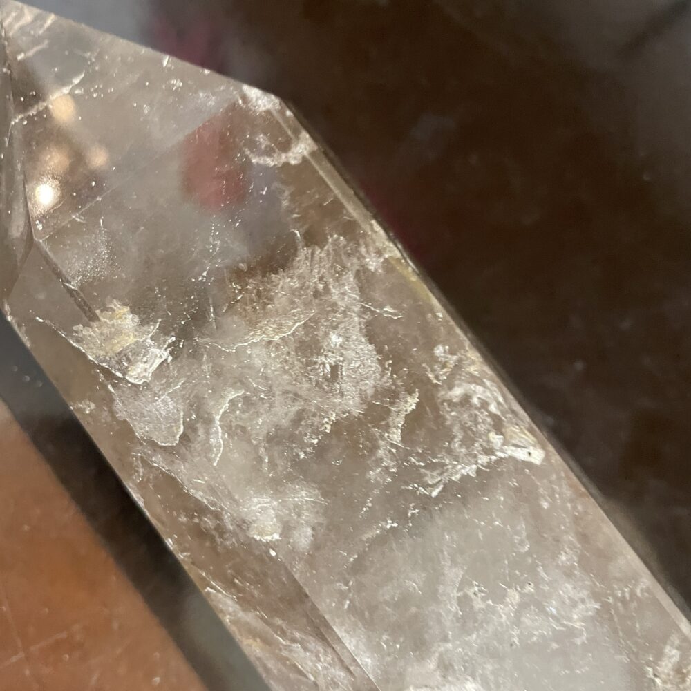 A close-up of the Rare 19.8 Inches Long Milky and Clear Quartz Crystal (6 lbs 12 oz/3068g) displays natural surface inclusions and imperfections, resting on a dark background.