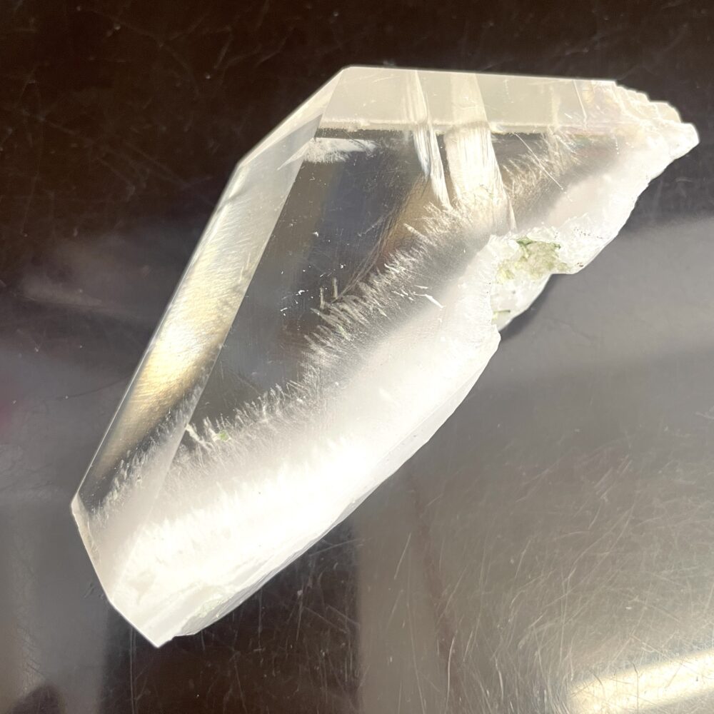 A rare Okenite inside Optical Calcite from India, 7.5 oz, with sharp edges and clarity on a reflective dark surface.