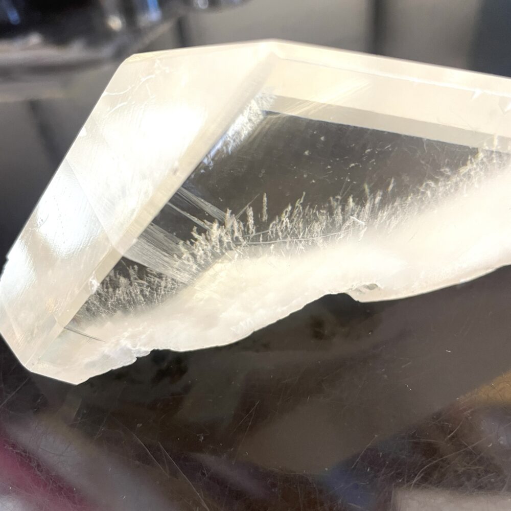 A close-up of Rare Okenite inside Optical Calcite (Icelandic Spar) from India, 7.5 oz, with white inclusions on black.